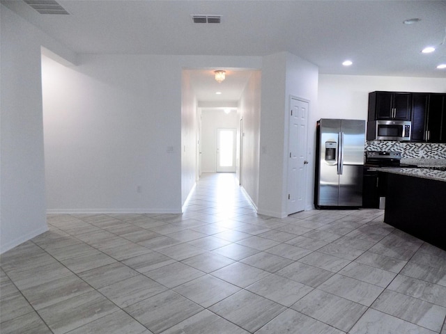 kitchen with decorative backsplash, appliances with stainless steel finishes, and light tile patterned flooring