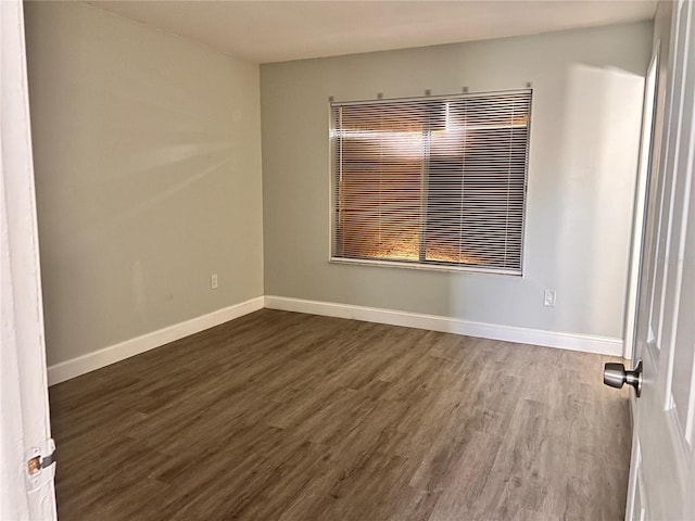 unfurnished room with dark hardwood / wood-style flooring