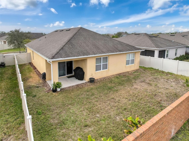 rear view of house with a yard and a patio area