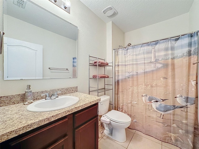 bathroom with toilet, vanity, tile patterned floors, a textured ceiling, and curtained shower