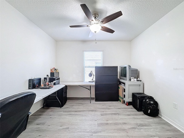 office featuring a textured ceiling, ceiling fan, and light wood-type flooring