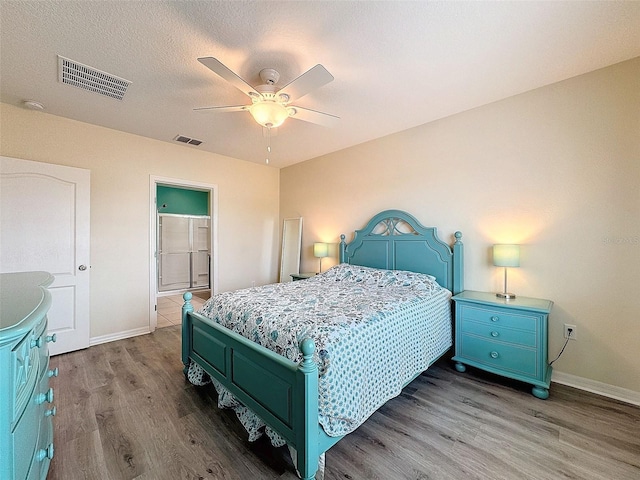 bedroom featuring connected bathroom, hardwood / wood-style floors, and ceiling fan