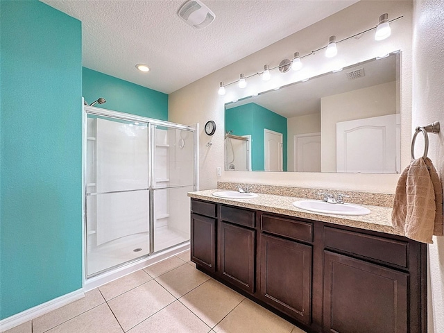 bathroom featuring an enclosed shower, tile patterned flooring, a textured ceiling, and vanity