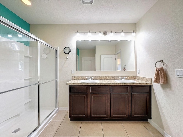 bathroom with an enclosed shower, tile patterned floors, a textured ceiling, and vanity