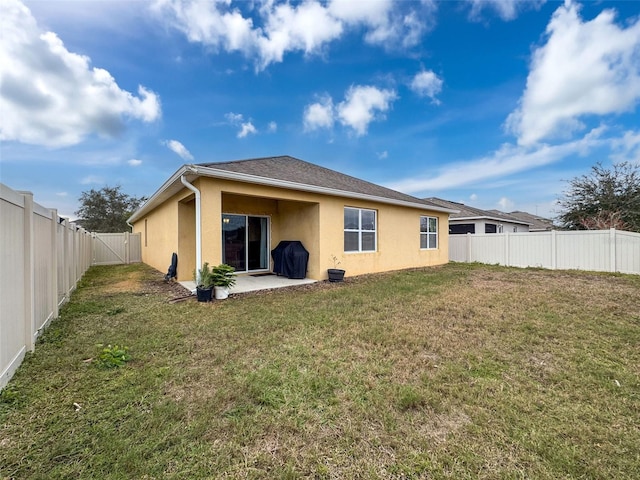 rear view of house with a patio area and a lawn