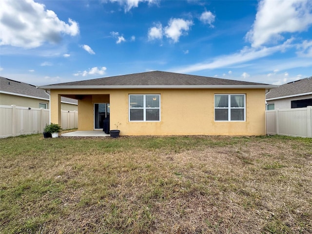 back of property featuring a patio and a lawn