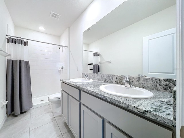 bathroom with toilet, tile patterned flooring, vanity, and curtained shower