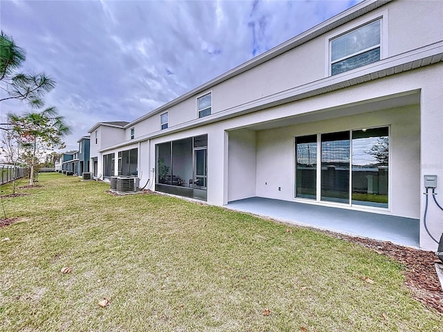 back of house with a lawn, central air condition unit, and a patio area