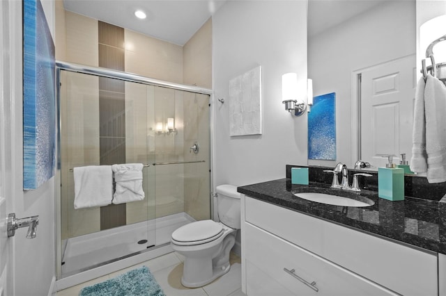 bathroom with tile patterned flooring, vanity, a shower with door, and toilet