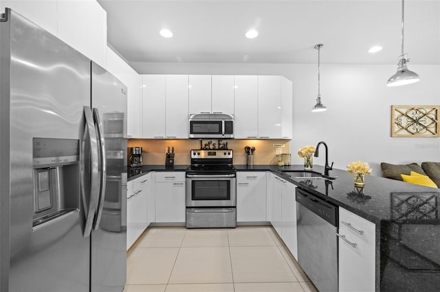 kitchen featuring sink, decorative light fixtures, light tile patterned floors, appliances with stainless steel finishes, and white cabinets