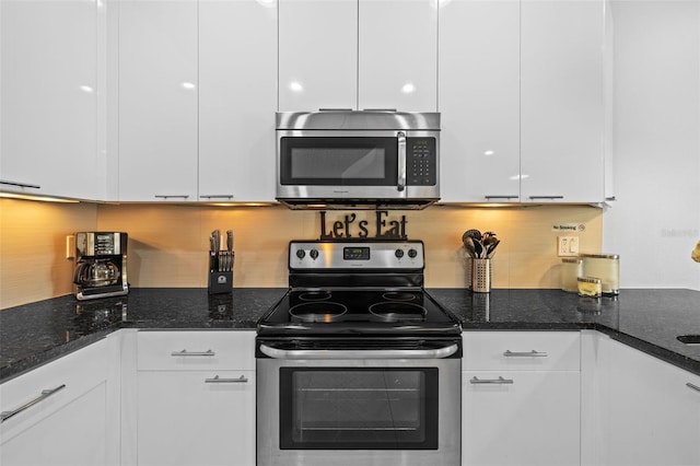 kitchen featuring dark stone countertops, backsplash, stainless steel appliances, and white cabinets