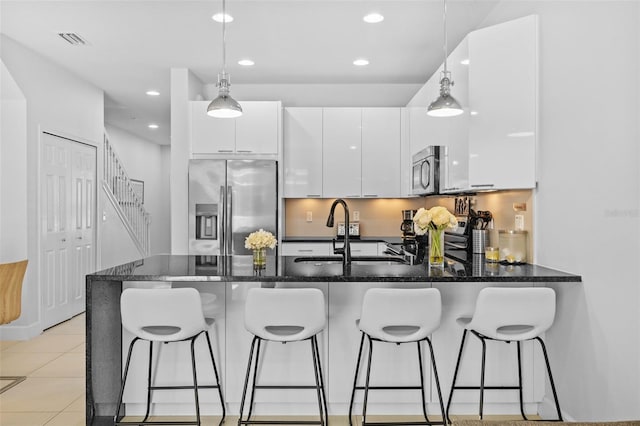 kitchen featuring pendant lighting, sink, white cabinetry, and appliances with stainless steel finishes