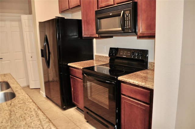 kitchen with black appliances, light tile patterned floors, and light stone countertops