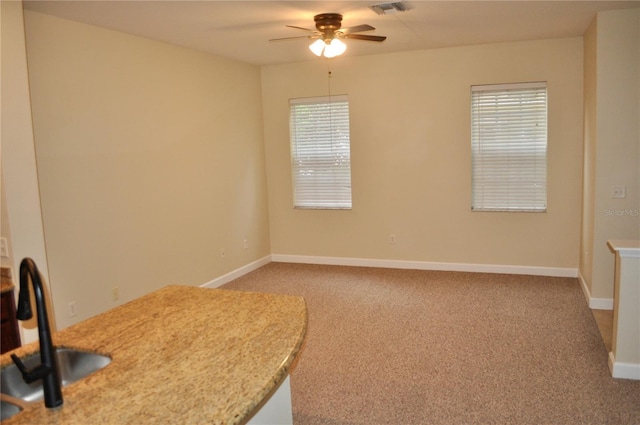 interior space with ceiling fan, light colored carpet, and sink