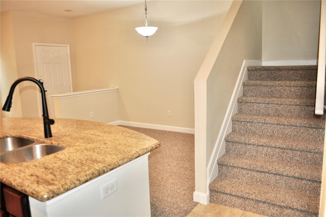 kitchen featuring sink, hanging light fixtures, and light carpet