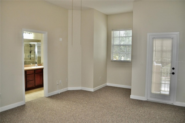 spare room featuring light carpet and sink