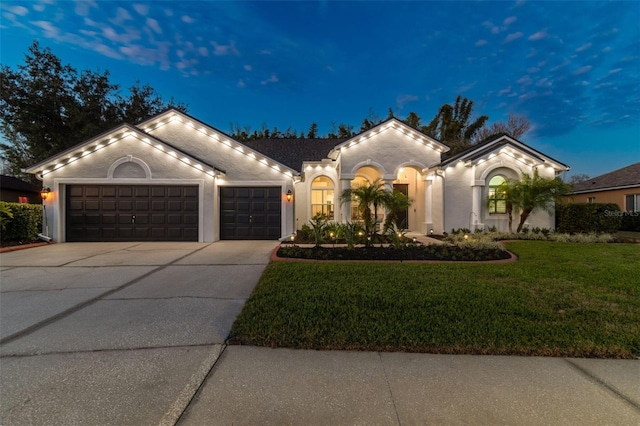 mediterranean / spanish-style home featuring a lawn and a garage