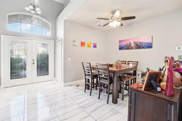 dining area featuring ceiling fan with notable chandelier and french doors