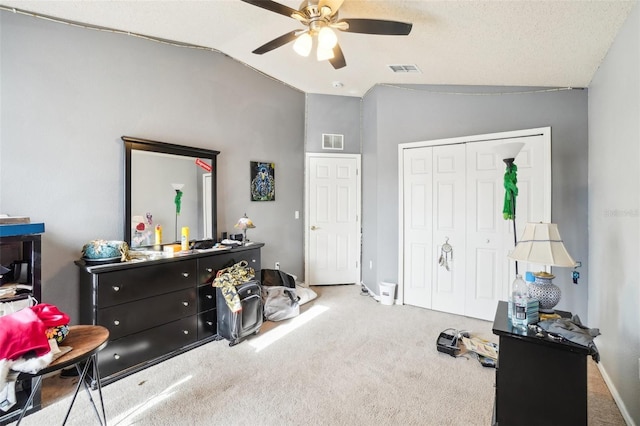 carpeted bedroom featuring vaulted ceiling, ceiling fan, a closet, and a textured ceiling