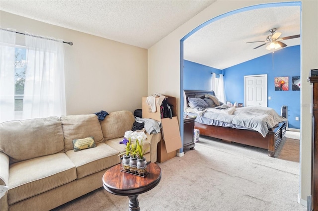 carpeted bedroom with vaulted ceiling, ceiling fan, a textured ceiling, and multiple windows