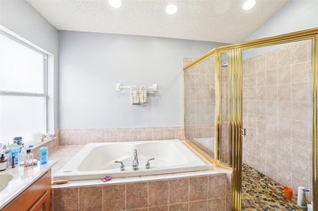 bathroom featuring a textured ceiling, separate shower and tub, and vanity