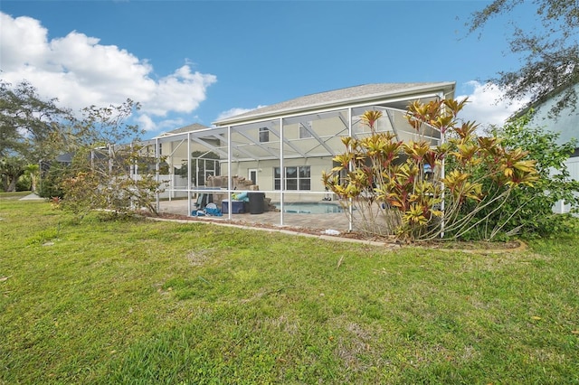 rear view of house with a lanai and a lawn