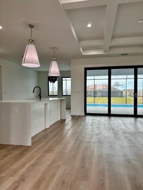 interior space featuring sink, light wood-type flooring, and beamed ceiling