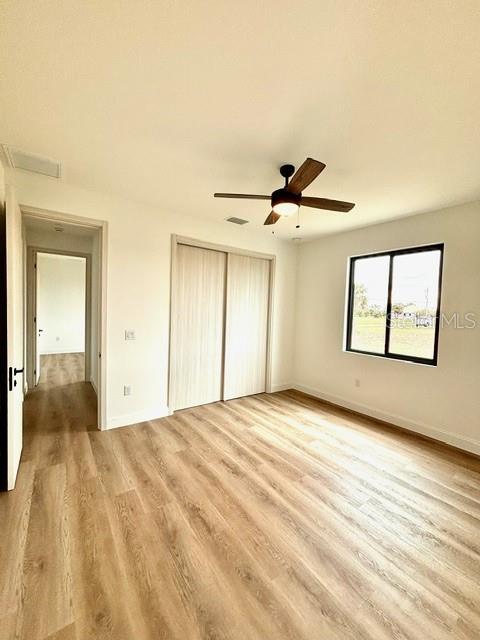 unfurnished bedroom featuring ceiling fan and light hardwood / wood-style floors