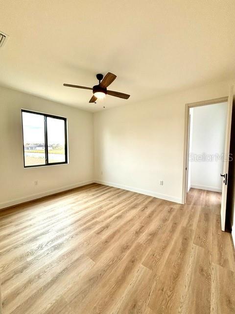 spare room featuring ceiling fan and light hardwood / wood-style floors