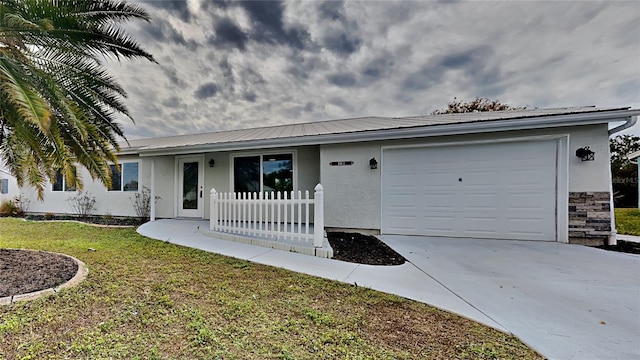 single story home featuring a front lawn and a garage