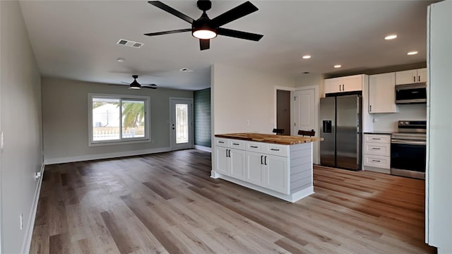 kitchen featuring wooden counters, stainless steel appliances, light wood-type flooring, ceiling fan, and white cabinetry