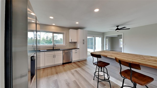 kitchen featuring stainless steel appliances, sink, white cabinets, light wood-type flooring, and ceiling fan