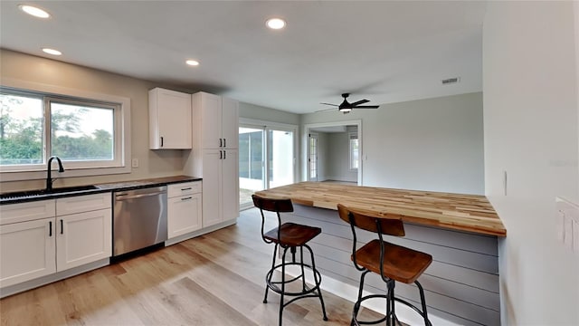 kitchen with sink, white cabinetry, ceiling fan, light wood-type flooring, and stainless steel dishwasher