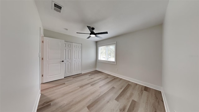 unfurnished bedroom featuring light wood-type flooring, ceiling fan, and a closet