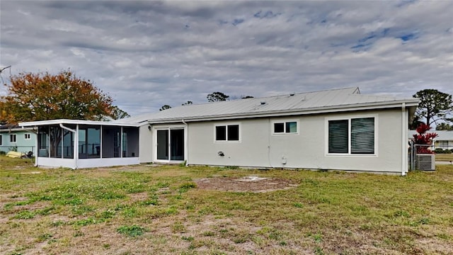 back of property with a yard and a sunroom