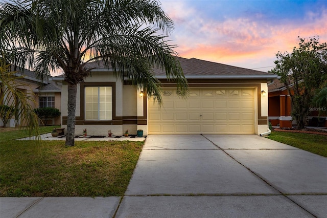 ranch-style home featuring a garage and a yard