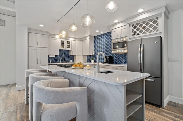 kitchen featuring dark hardwood / wood-style flooring, stainless steel appliances, white cabinetry, and decorative light fixtures