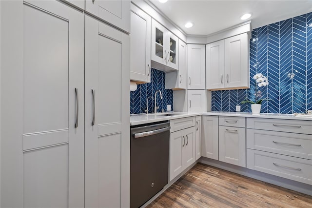 kitchen with white cabinets, dark wood-type flooring, dishwasher, and sink