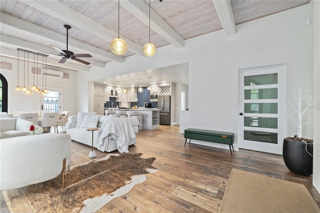 living room with wood-type flooring, wood ceiling, ceiling fan, and beamed ceiling