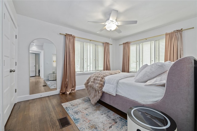 bedroom with dark wood-type flooring, ceiling fan, and multiple windows