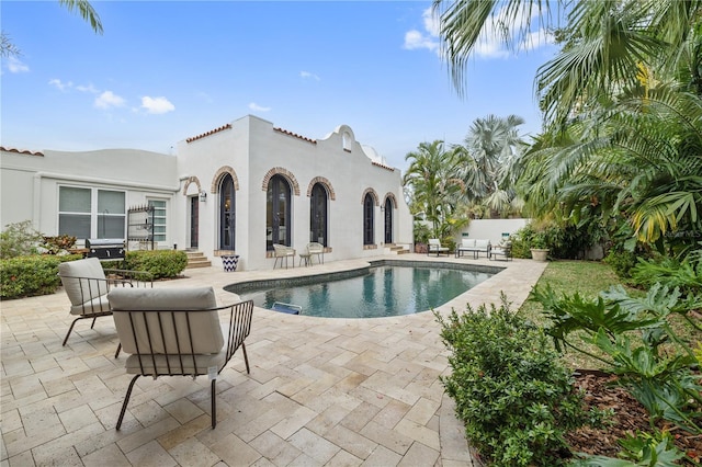 view of pool featuring a patio area and a grill