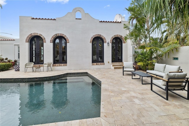 view of pool with an outdoor hangout area, a patio area, and french doors