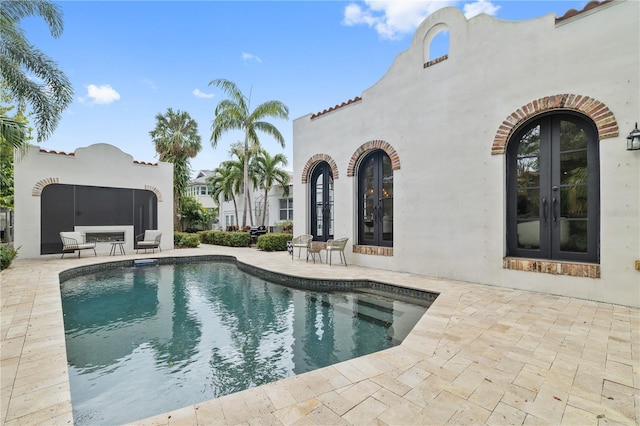 view of swimming pool with french doors and a patio