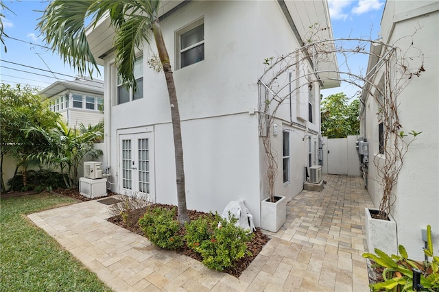 view of side of property featuring central AC unit, french doors, and a patio area