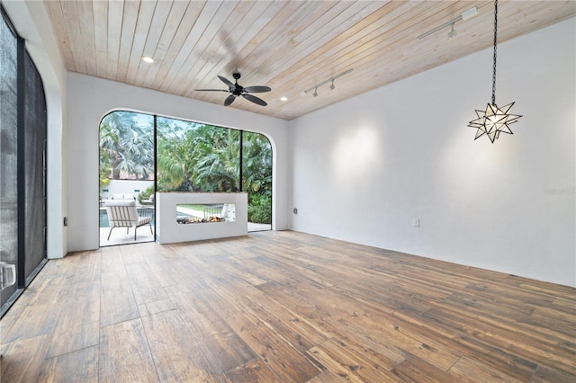 unfurnished living room featuring ceiling fan, wood ceiling, track lighting, and wood-type flooring