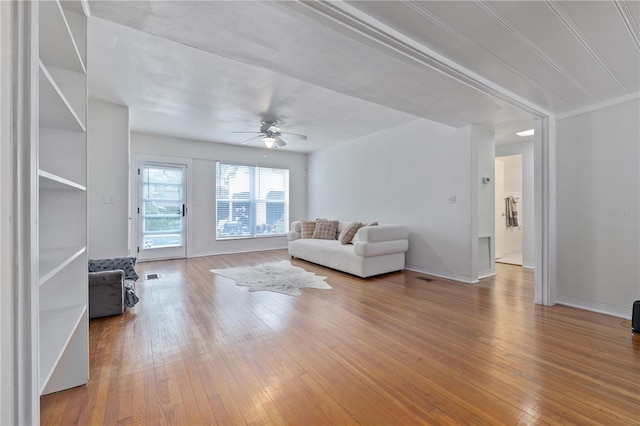 unfurnished living room with hardwood / wood-style floors, ceiling fan, and crown molding