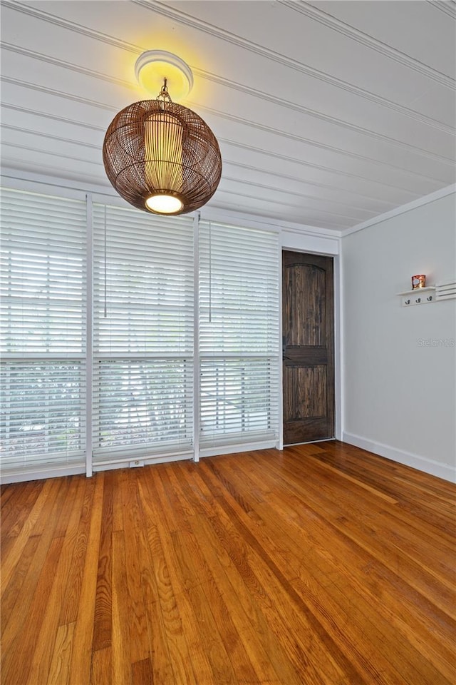 spare room featuring crown molding and hardwood / wood-style flooring