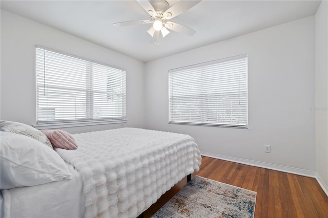 bedroom with dark hardwood / wood-style flooring and ceiling fan