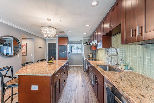 kitchen with a kitchen breakfast bar, a center island, light stone countertops, ornamental molding, and sink