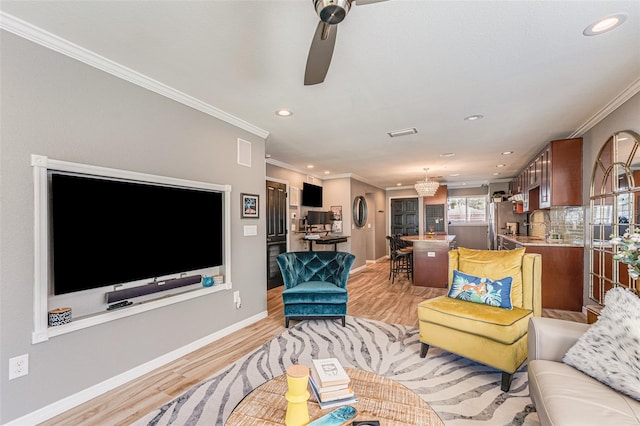 living room with ornamental molding, ceiling fan, and light hardwood / wood-style floors